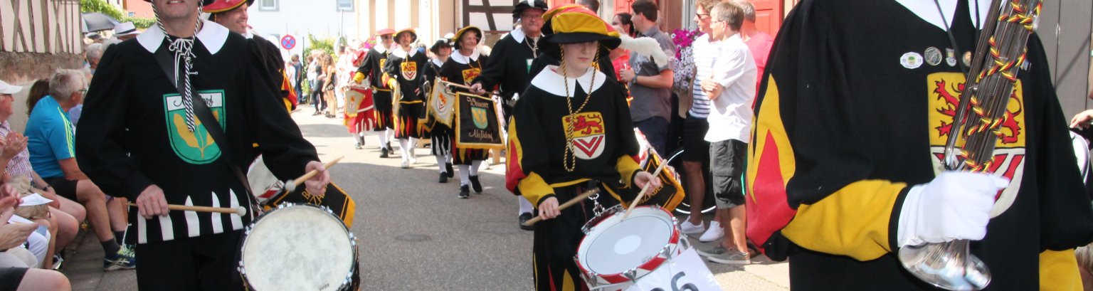 mehrere Personen in Tracht mit Trommel und anderen Instrumenten