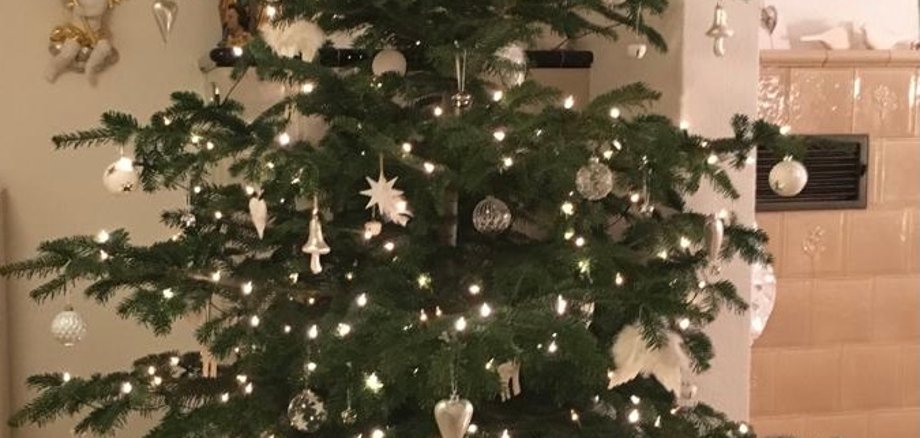 Weihnachtsbaum mit Lichtern, Kugeln und Geschenken