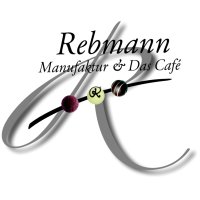ein großes geschwungenes R wird durchkreuzt mit drei Pralinen an einem Stab; darüber der Schriftzug "Rebmann Manufaktur & Café"